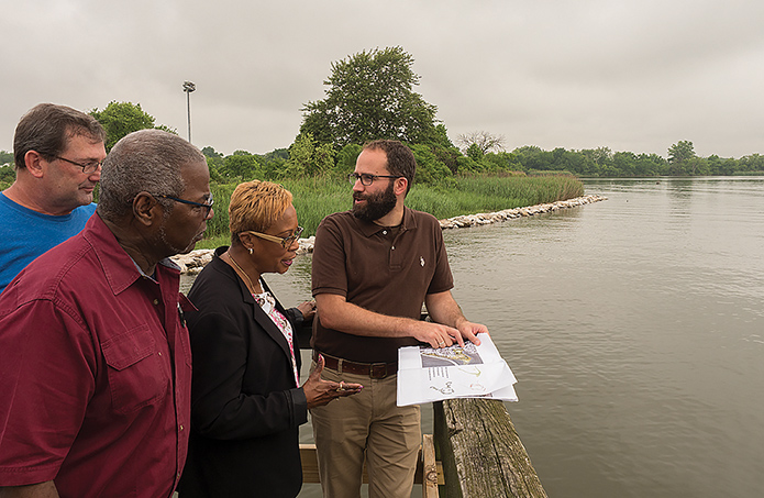 Isaac Hametz (right), of the landscape design firm Mahan Rykiel Associates, reviews park upgrade plans with (from left) Doug Myers of the Chesapeake Bay Foundation and Larry Bannerman and Gloria Nelson of the Turner Station Conservation Teams. (Dave Harp)